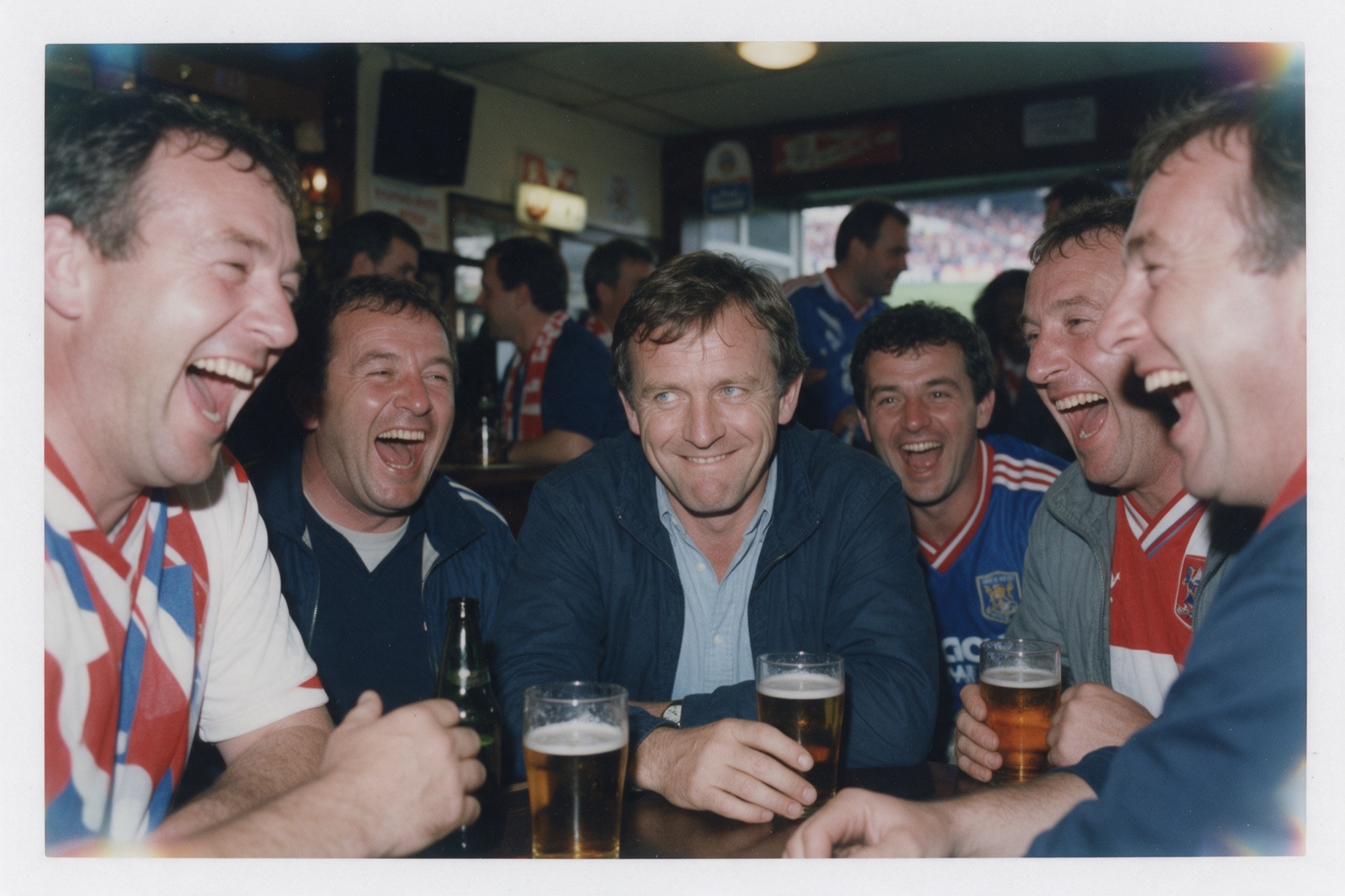 Fotografia d'estil Polaroid dels anys vuitanta: un grup d'amics riu en un bar mentre un d'ells força un somriure amb la mirada perduda